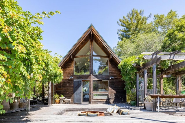 back of house with a deck and a fire pit