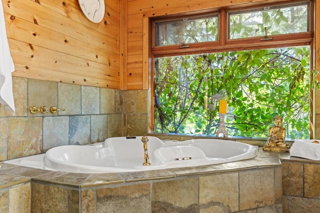 bathroom with a relaxing tiled tub and plenty of natural light