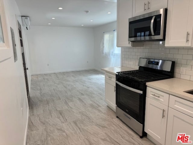 kitchen featuring white cabinets, decorative backsplash, and appliances with stainless steel finishes