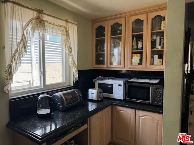 kitchen with wine cooler and dark stone counters