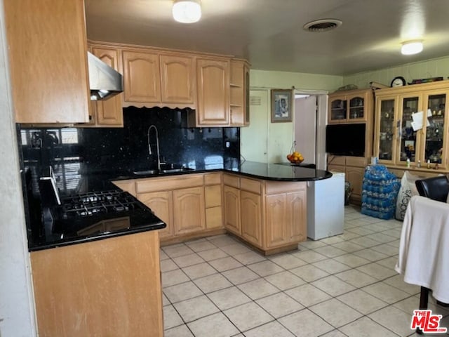 kitchen with sink, tasteful backsplash, light tile patterned floors, range hood, and light brown cabinetry