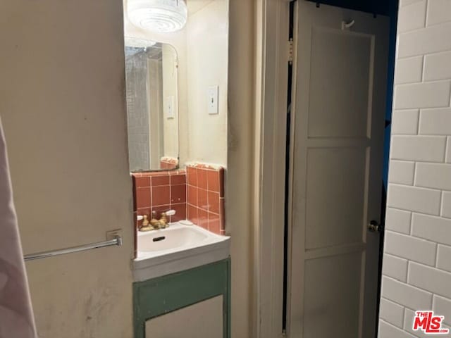 bathroom with vanity and tasteful backsplash