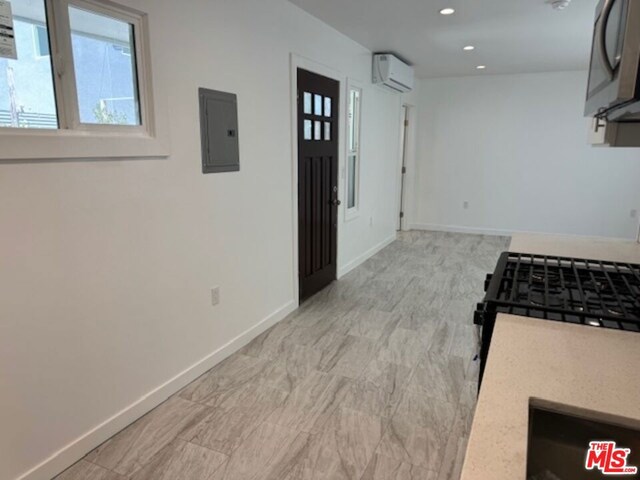 kitchen with an AC wall unit and electric panel