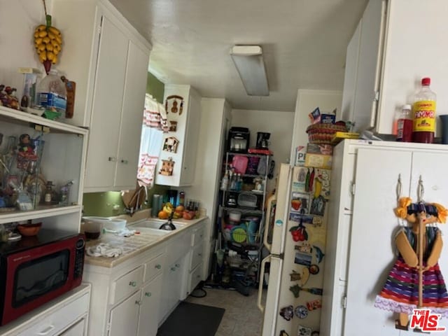 kitchen with sink, white cabinets, and white refrigerator