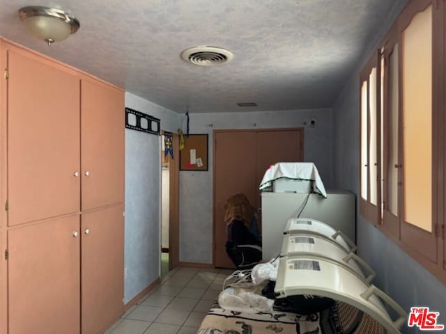 interior space with light tile patterned floors and a textured ceiling