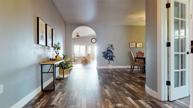 corridor with vaulted ceiling and dark hardwood / wood-style floors