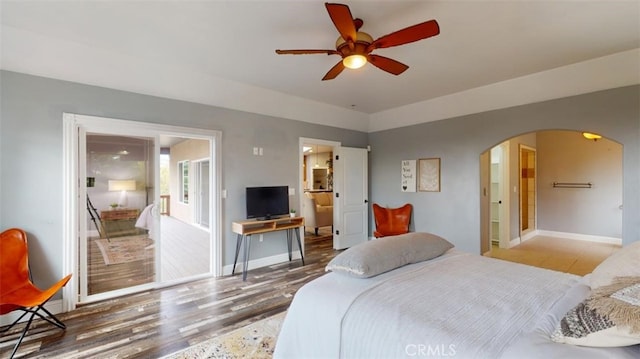 bedroom with ensuite bathroom, wood-type flooring, and ceiling fan