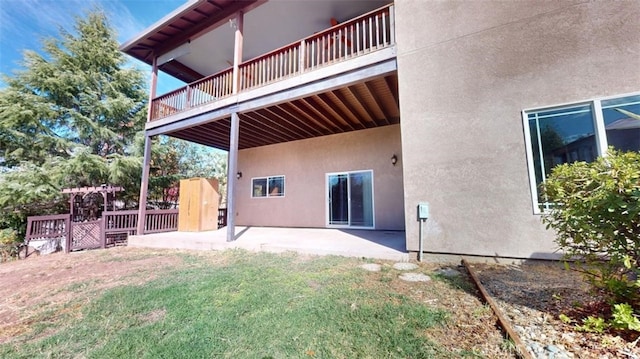 back of house featuring a patio area, a yard, and a balcony