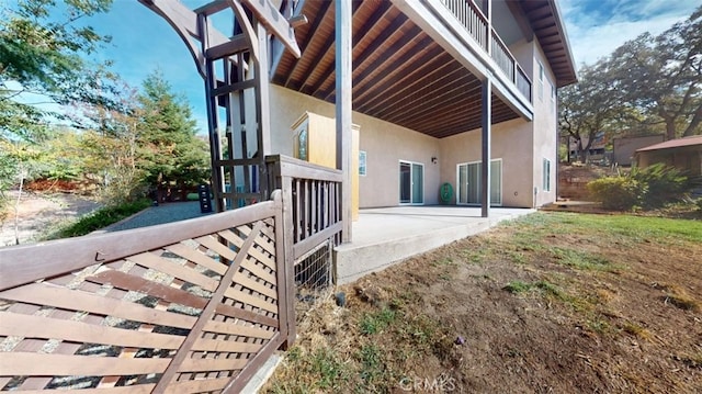 view of property exterior with a patio area and a balcony