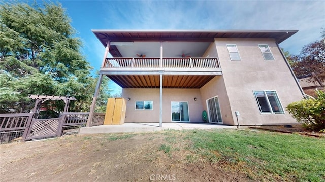 rear view of house with a patio area, a yard, and a balcony