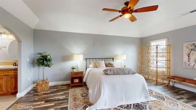 bedroom featuring ceiling fan, sink, and dark hardwood / wood-style floors