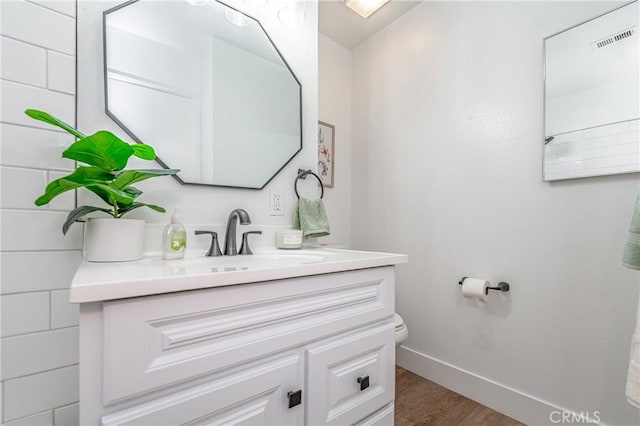 bathroom featuring vanity, wood-type flooring, and toilet