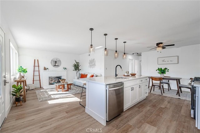 kitchen with stainless steel appliances, sink, light hardwood / wood-style flooring, white cabinetry, and an island with sink