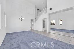 unfurnished living room featuring tile patterned flooring and a high ceiling