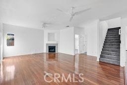 unfurnished living room with ceiling fan and wood-type flooring