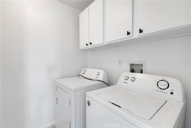 washroom with cabinets and washer and dryer