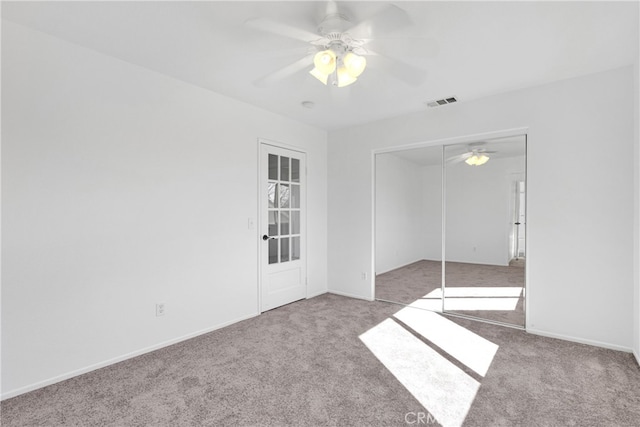 carpeted spare room featuring ceiling fan