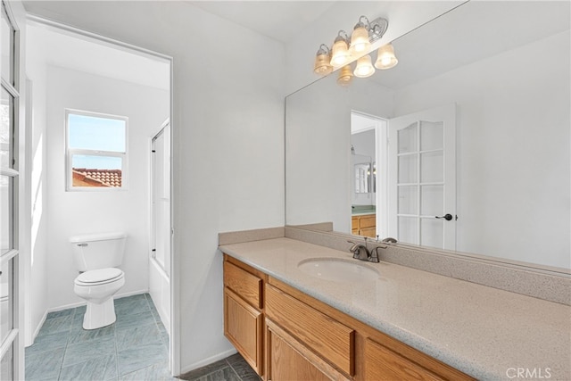 bathroom with vanity, toilet, and a notable chandelier