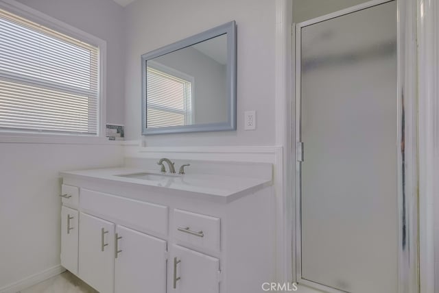 bathroom with vanity and a shower with door