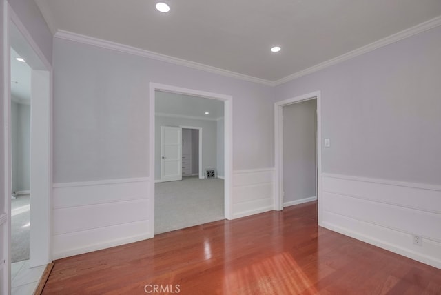 spare room featuring crown molding and hardwood / wood-style flooring