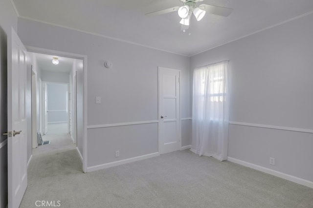 carpeted empty room with ceiling fan and ornamental molding