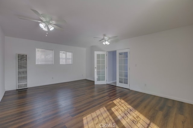 empty room with french doors, ceiling fan, and dark wood-type flooring