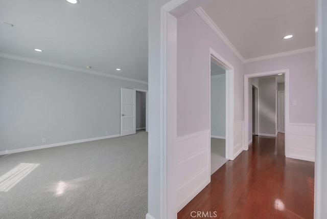 corridor featuring dark colored carpet and crown molding