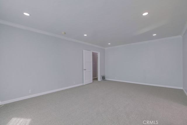 spare room featuring light colored carpet and crown molding