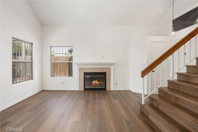 unfurnished living room featuring dark hardwood / wood-style floors and a tile fireplace