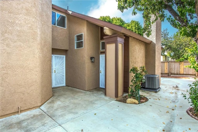 entrance to property featuring a patio and central AC