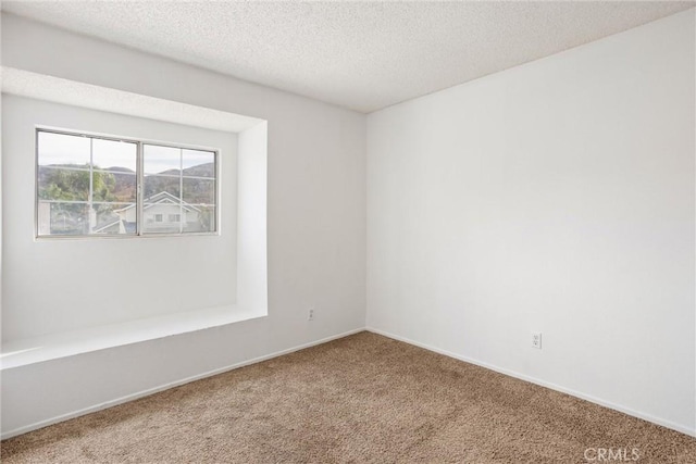 unfurnished room with a textured ceiling and carpet floors