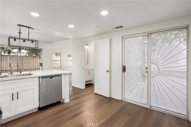 kitchen featuring pendant lighting, sink, stainless steel dishwasher, dark hardwood / wood-style flooring, and white cabinetry