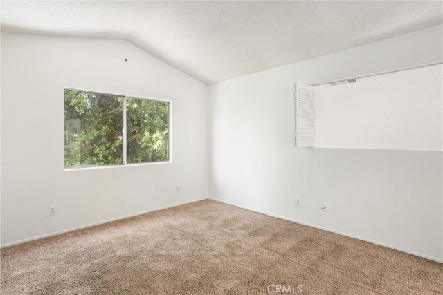 carpeted spare room featuring lofted ceiling