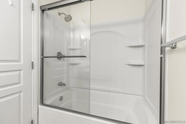 bathroom with shower / bath combination with glass door