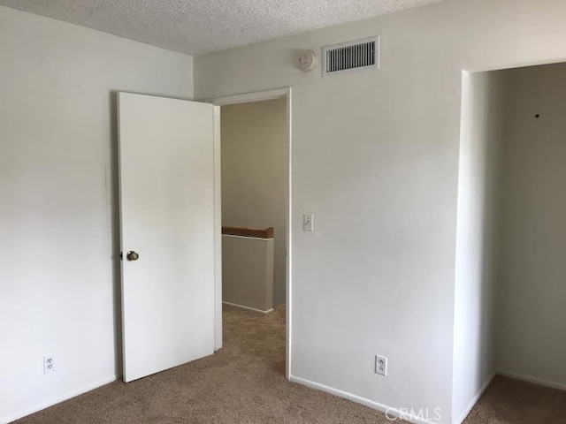 unfurnished bedroom featuring carpet flooring and a textured ceiling