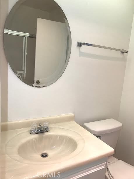 bathroom with vanity, an enclosed shower, and toilet