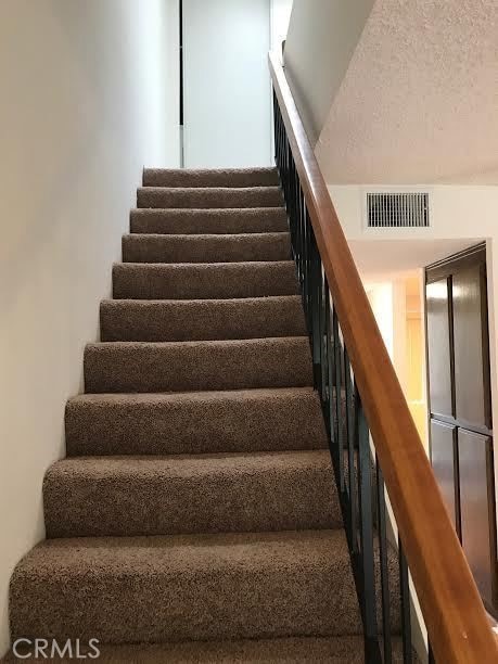 staircase with a textured ceiling