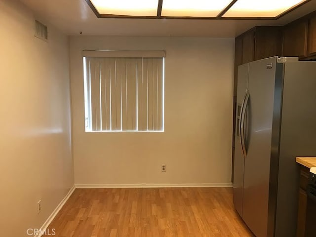 kitchen with dark brown cabinetry, stainless steel fridge with ice dispenser, and light hardwood / wood-style floors