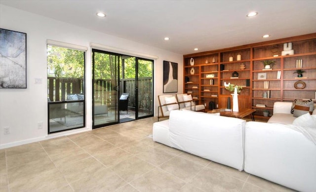 living room featuring built in shelves and light tile patterned floors