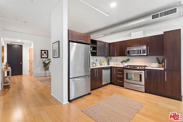 kitchen featuring dark brown cabinetry, stainless steel appliances, and light wood-type flooring