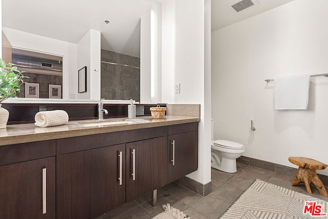 bathroom featuring tile patterned floors, walk in shower, vanity, and toilet