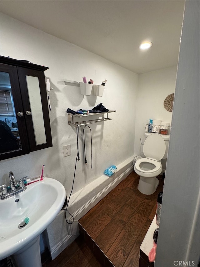 bathroom featuring sink, hardwood / wood-style floors, and toilet