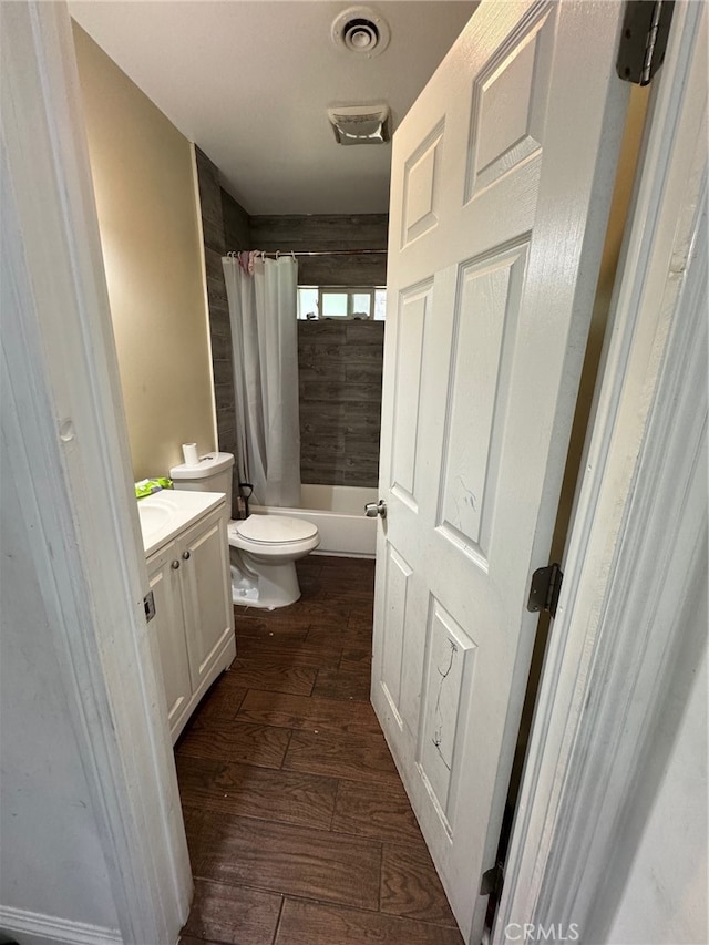 full bathroom with vanity, toilet, hardwood / wood-style flooring, and shower / tub combo