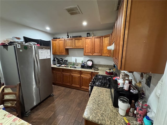 kitchen featuring sink, stainless steel appliances, dark wood-type flooring, light stone counters, and exhaust hood