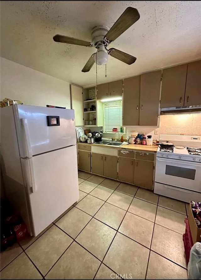 kitchen with white appliances, ceiling fan, light tile patterned flooring, and sink