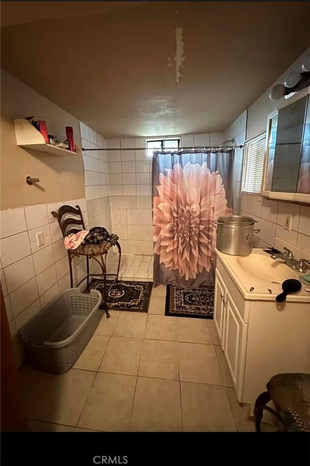 bathroom with tile walls, vanity, a shower with curtain, and tile patterned flooring