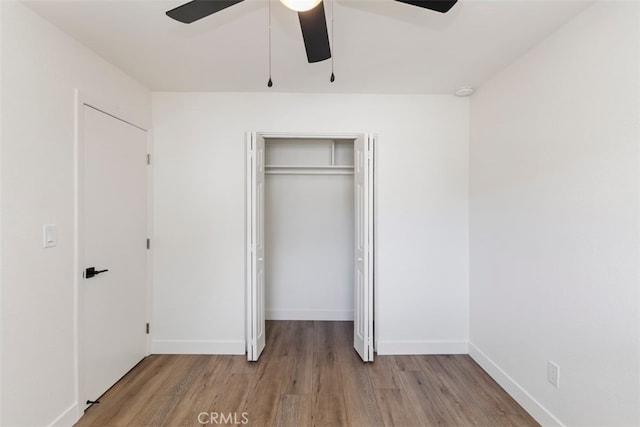 unfurnished bedroom featuring light hardwood / wood-style flooring, a closet, and ceiling fan