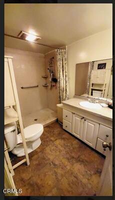 bathroom featuring vanity, toilet, and curtained shower