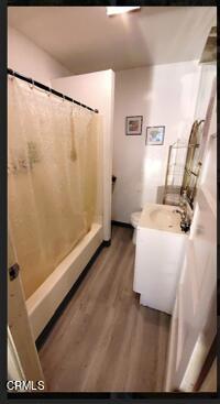 bathroom featuring vanity, curtained shower, toilet, and wood-type flooring