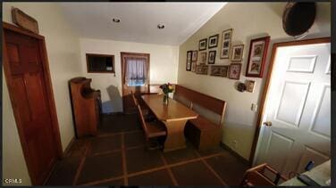 tiled dining space with lofted ceiling